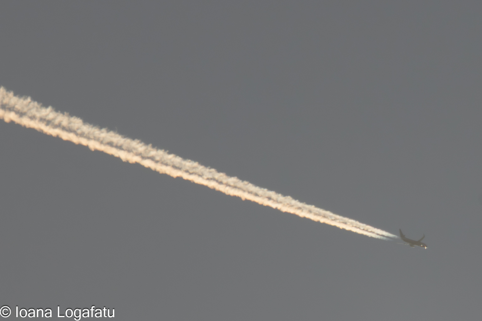 Jet trail gliding in the twilight sky